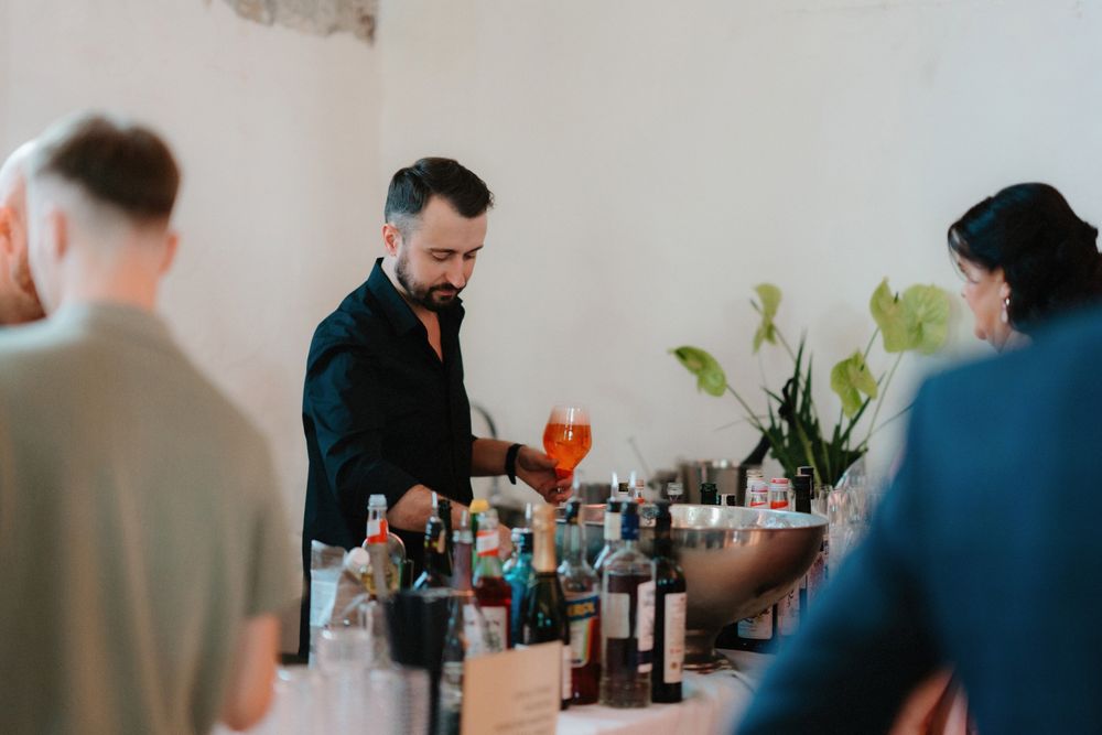 People mingling at a social gathering with drinks in a bright modern space.