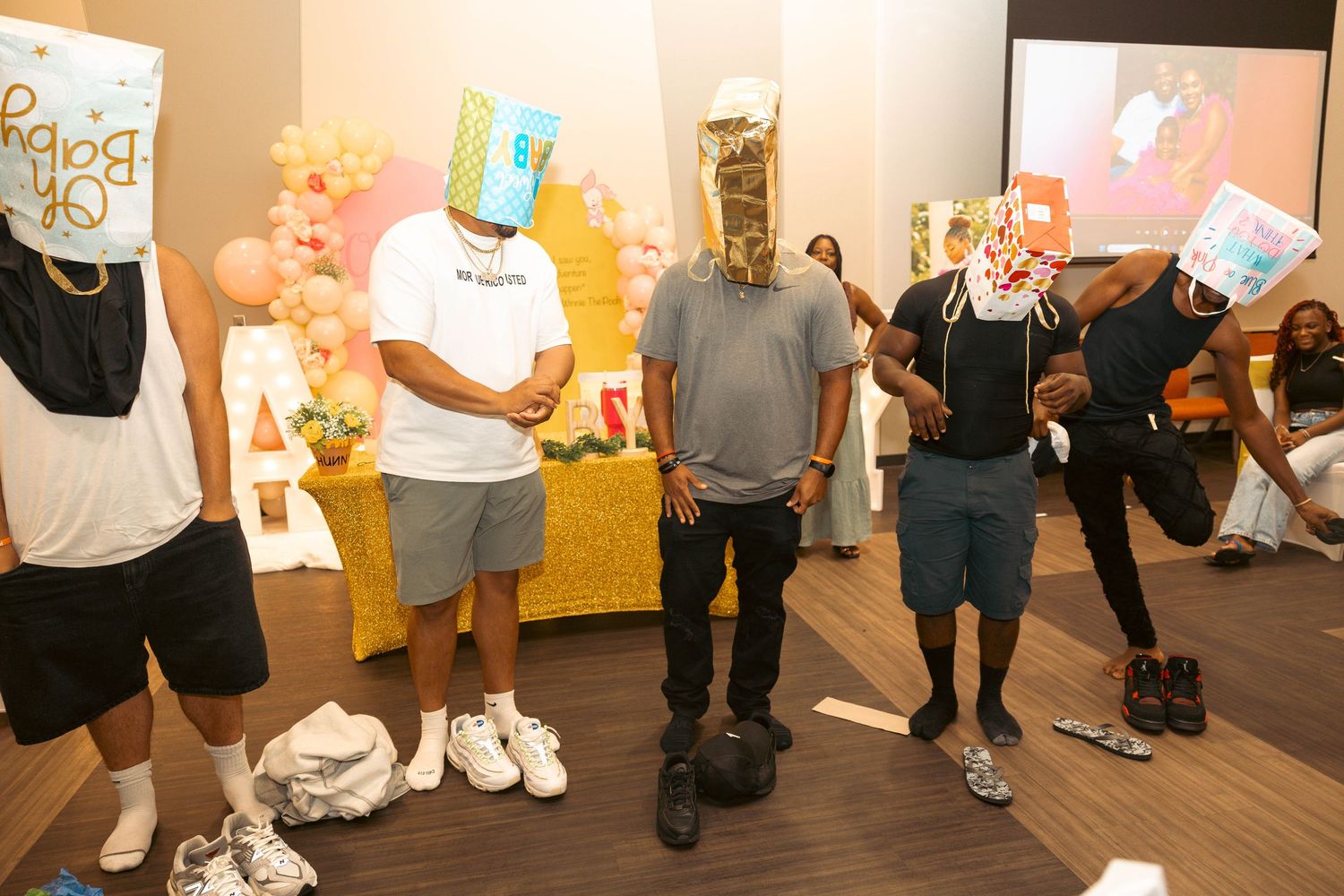 Group of men wearing baby-themed masks at a fun baby shower game.