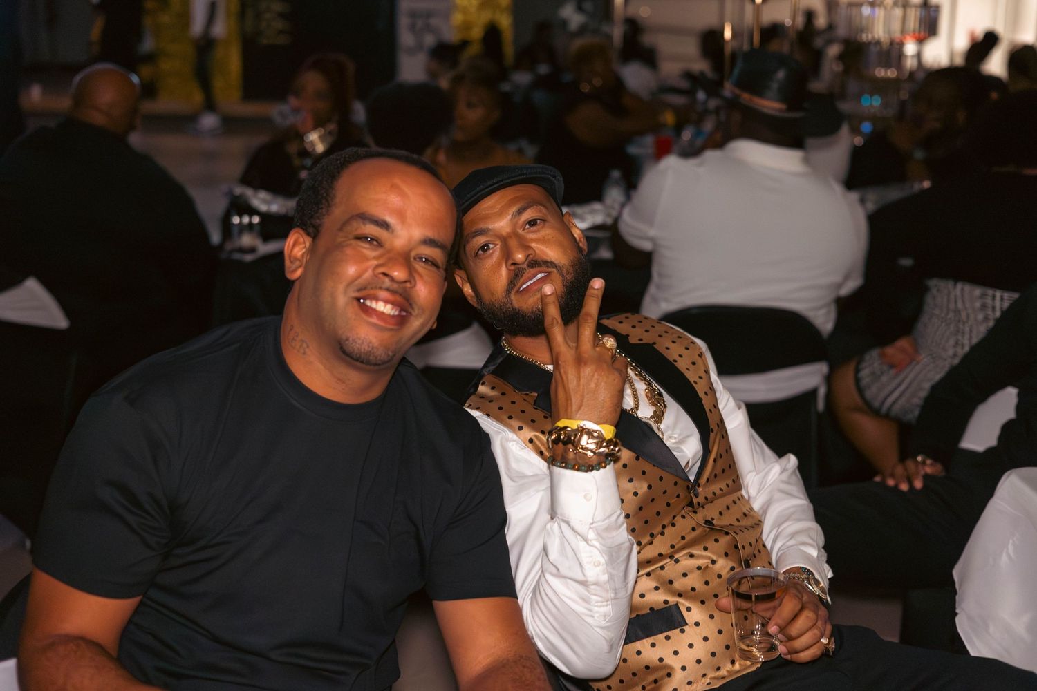 Two men smiling and posing together at a class reunion celebration event.