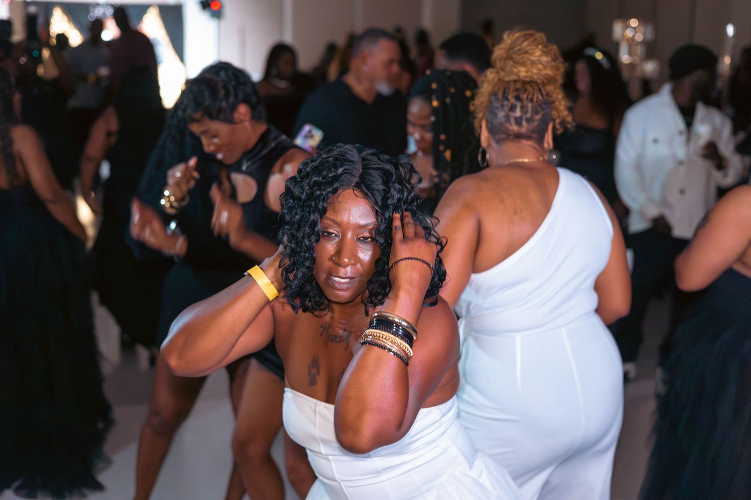 Guests dancing energetically on the dance floor at a lively class reunion party.