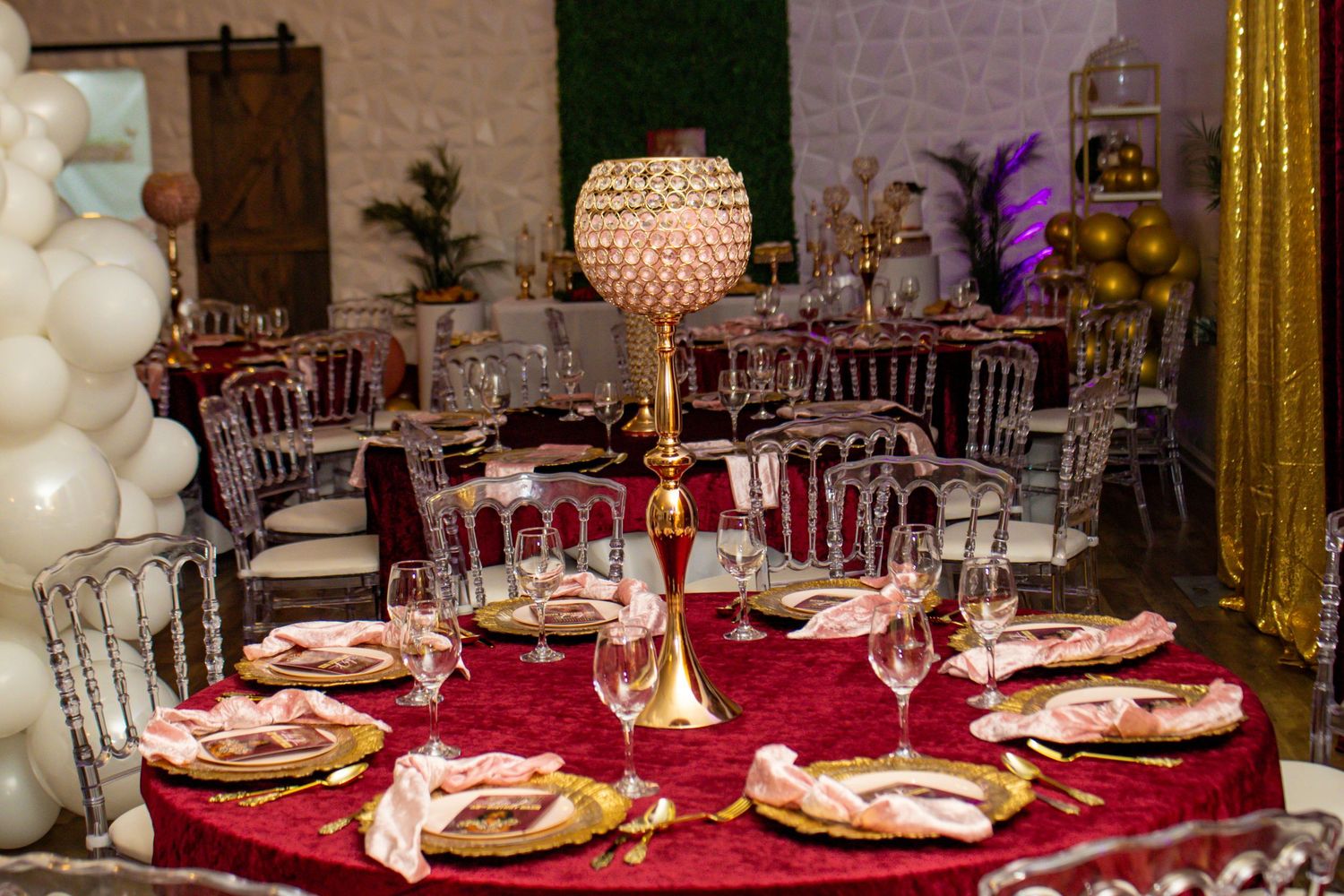 Glamorous event table setting with red velvet tablecloth, crystal globe centerpiece, and gold accents.