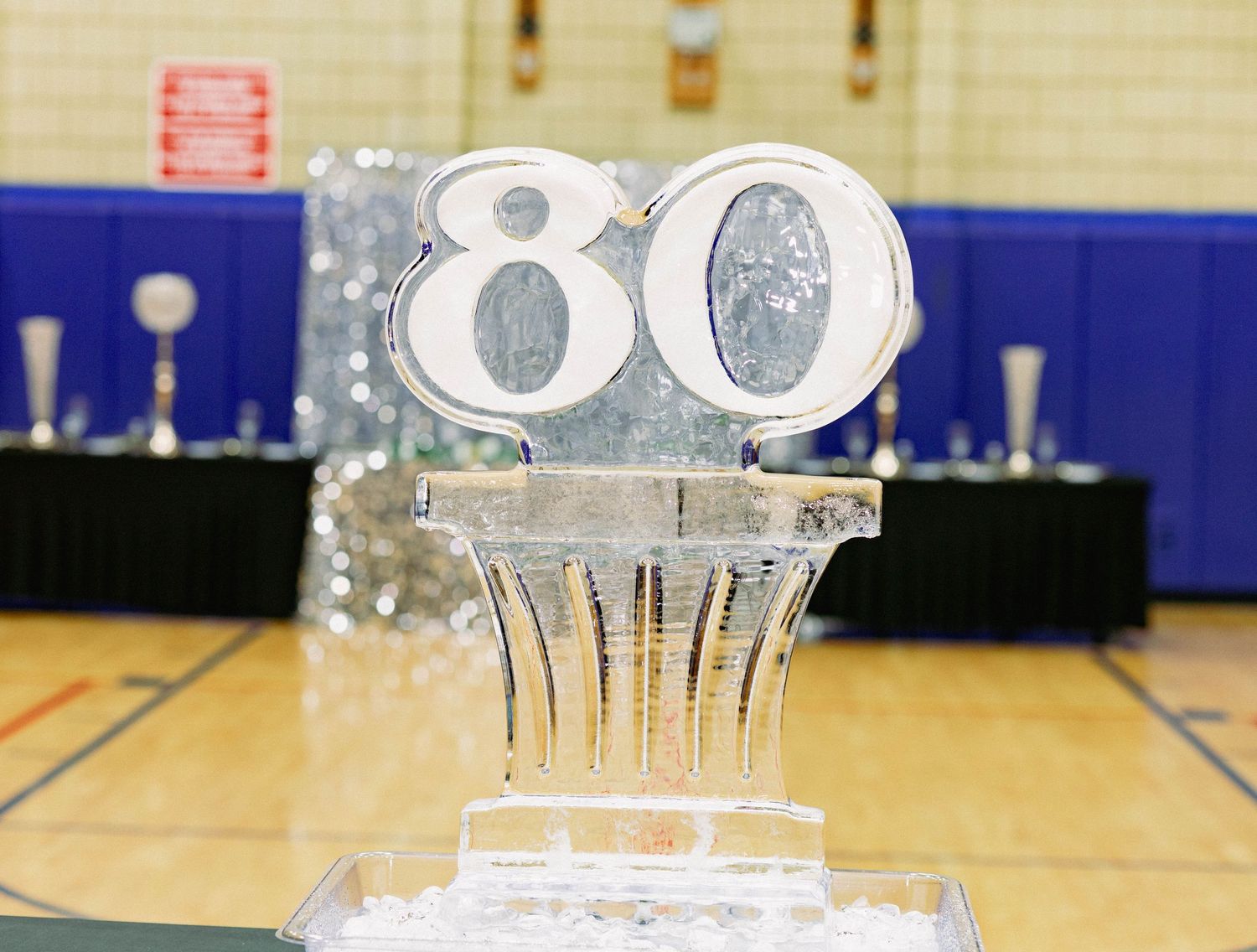 An ice sculpture displaying the number 80 centerpiece at a milestone birthday celebration.