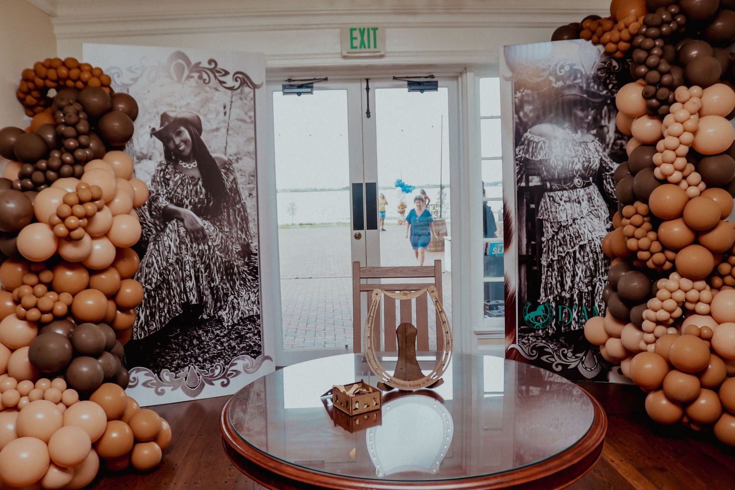 Elegant balloon arch display with vintage photos framing glass doors at an event venue.
