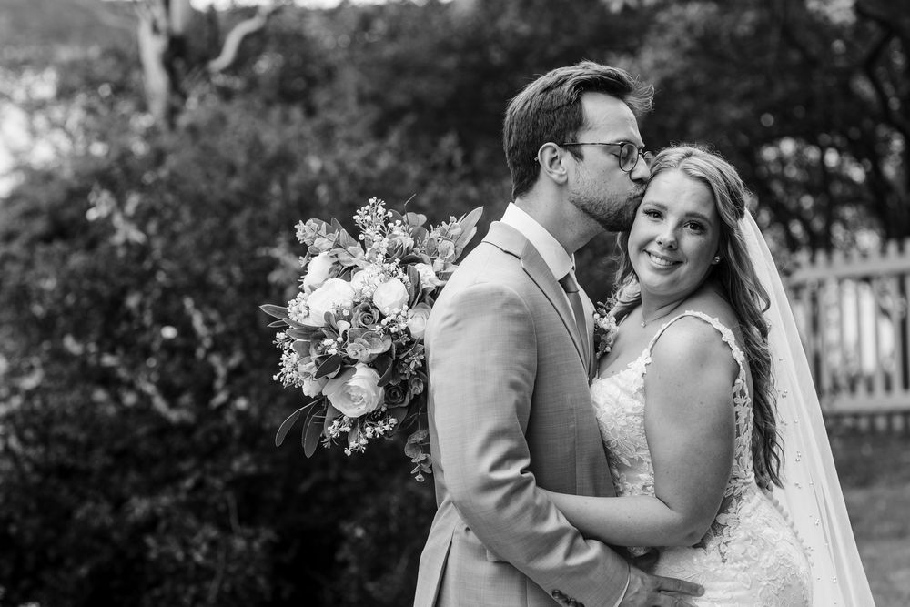 Black and white photography captures intimate wedding moments between couples in an elegant garden setting.