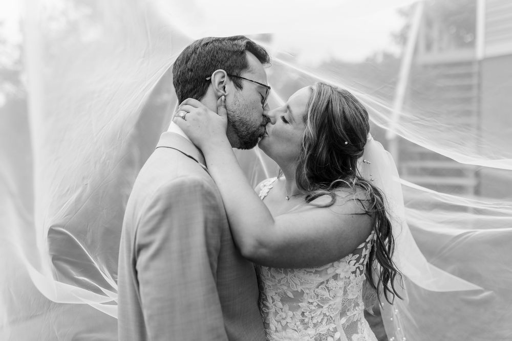 A series of four romantic black and white wedding photos showing intimate moments shared between a couple.