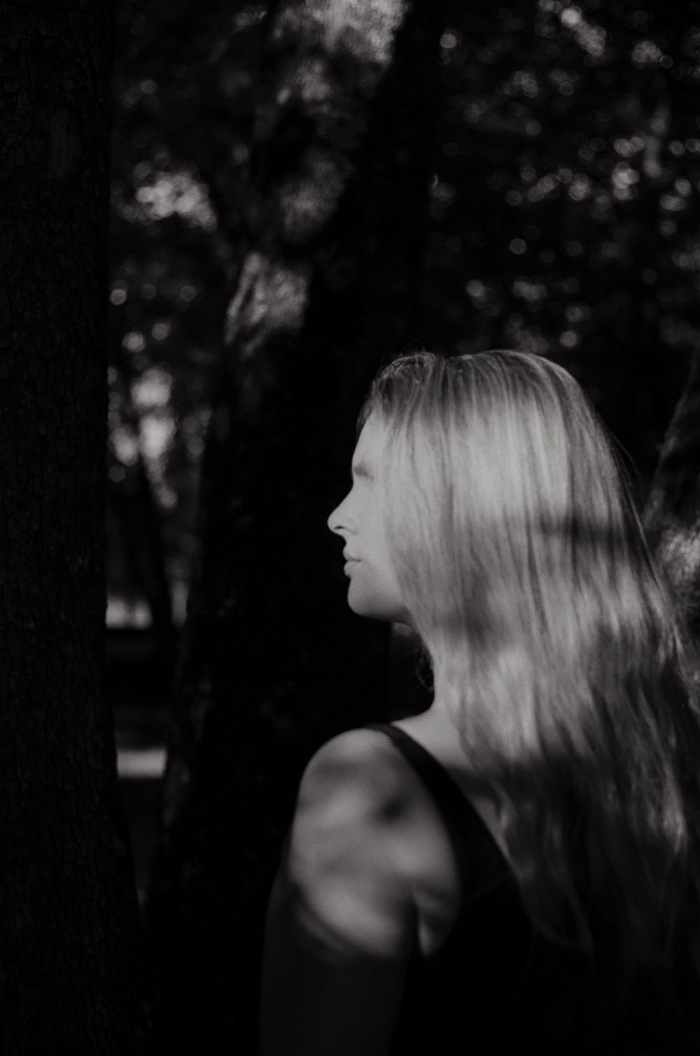 Black and white profile portrait with dramatic shadows and contrast.