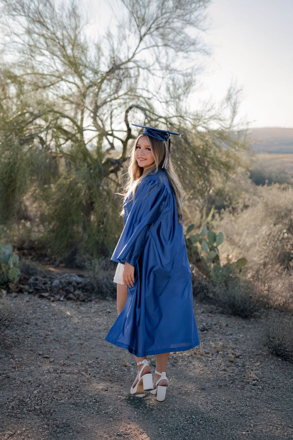 Tucson senior photos in desert, graduate in blue cap and gown, Class of 2026 portrait with cactus and golden hour light Arizona