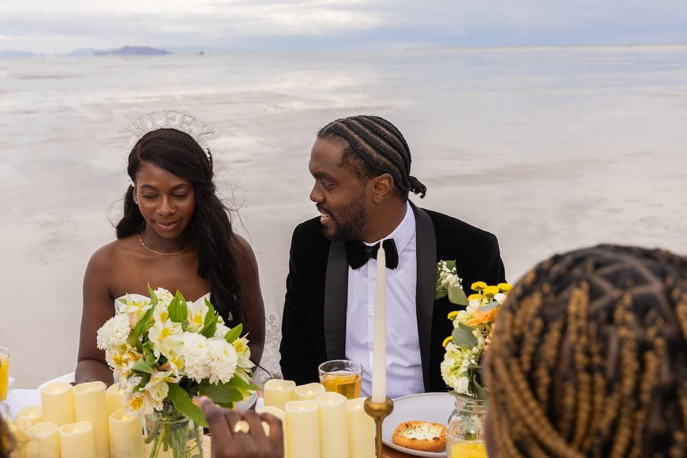 couple standing amid salt flats in a wedding attire ready for their first dance