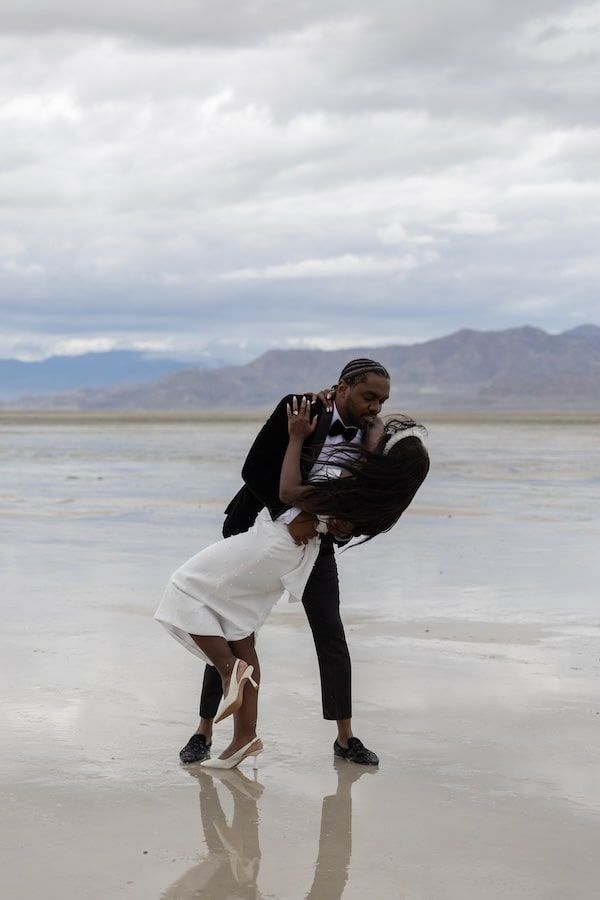 couple standing amid salt flats in a wedding attire ready for their first dance