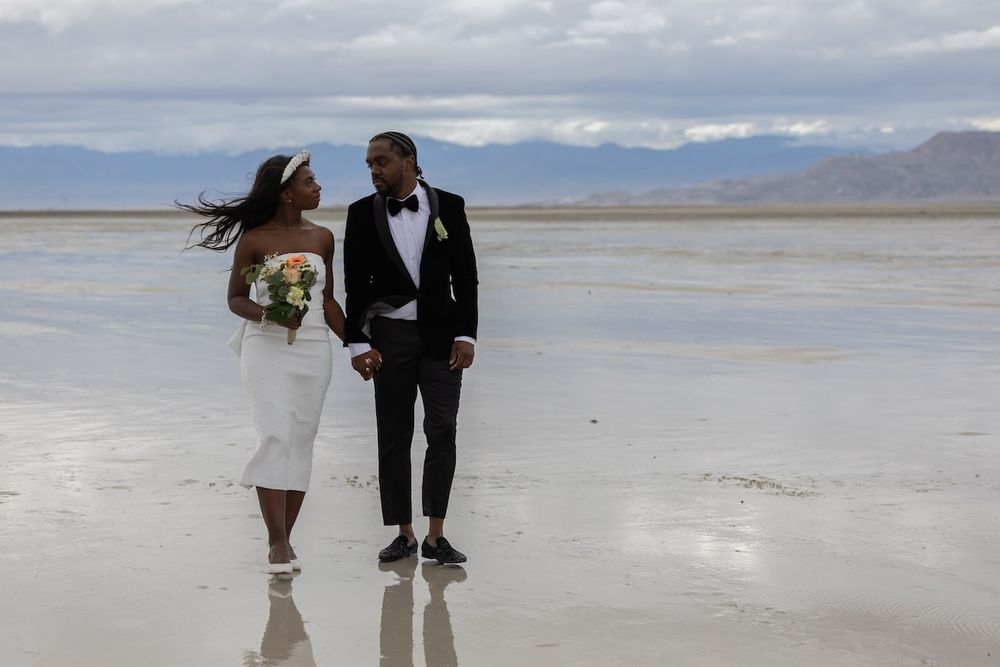 couple standing amid salt flats in a wedding attire ready for their first dance