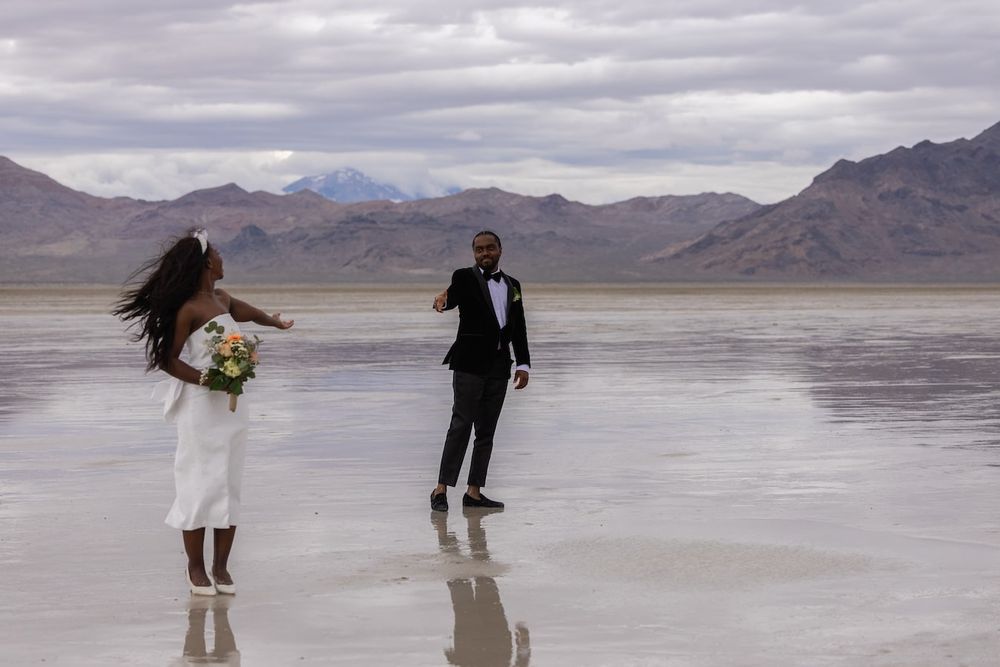 couple standing amid salt flats in a wedding attire ready for their first dance