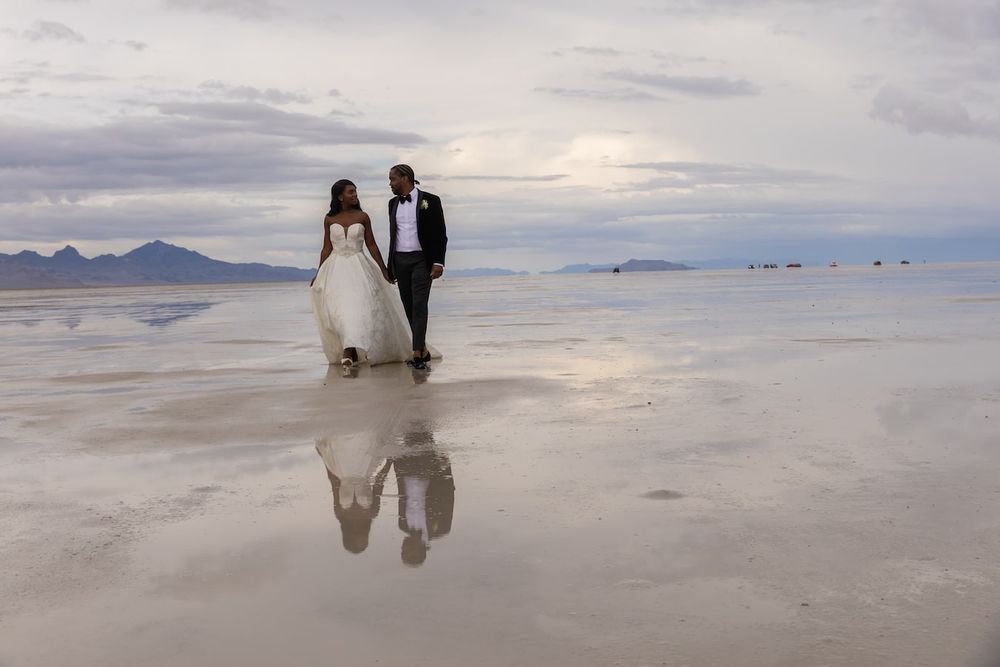 couple standing amid salt flats in a wedding attire ready for their first dance