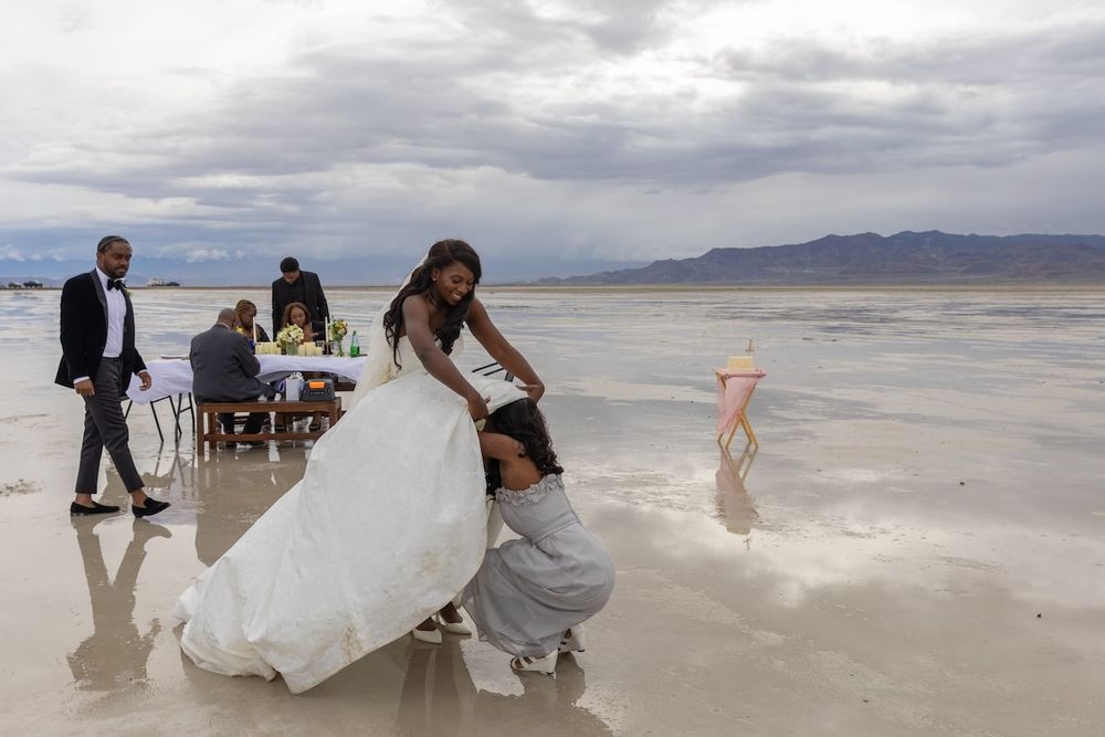 A coastal wedding ceremony on a scenic beach with mountains in the background as stormy clouds loom overhead.