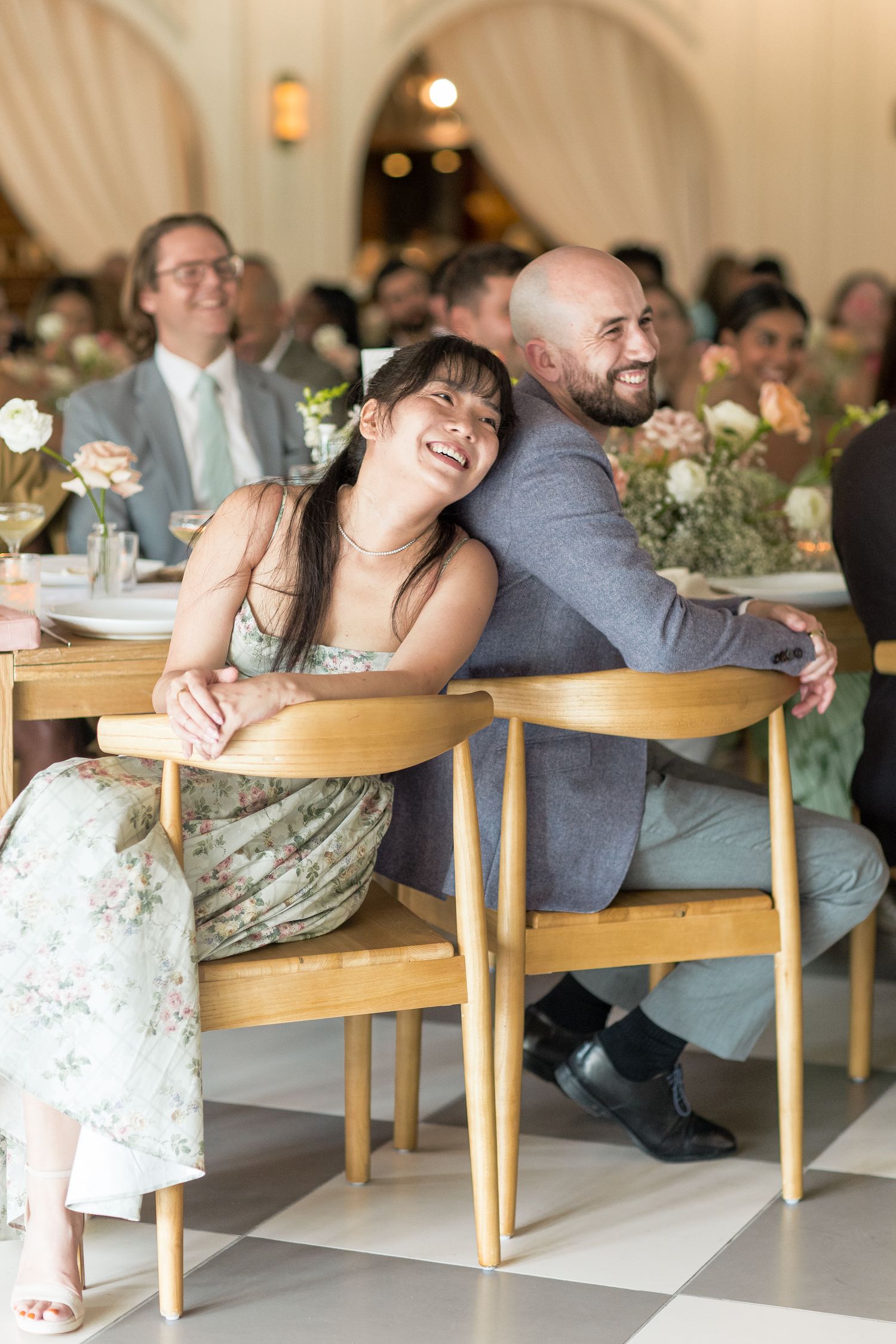 A couple sharing a sweet moment on a black and white checkered floor at an elegant reception venue.