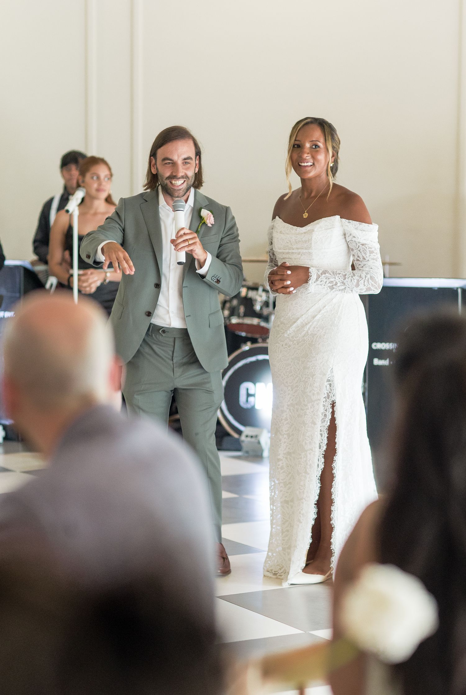 Wedding couple shares their first dance together surrounded by guests during their reception celebration.