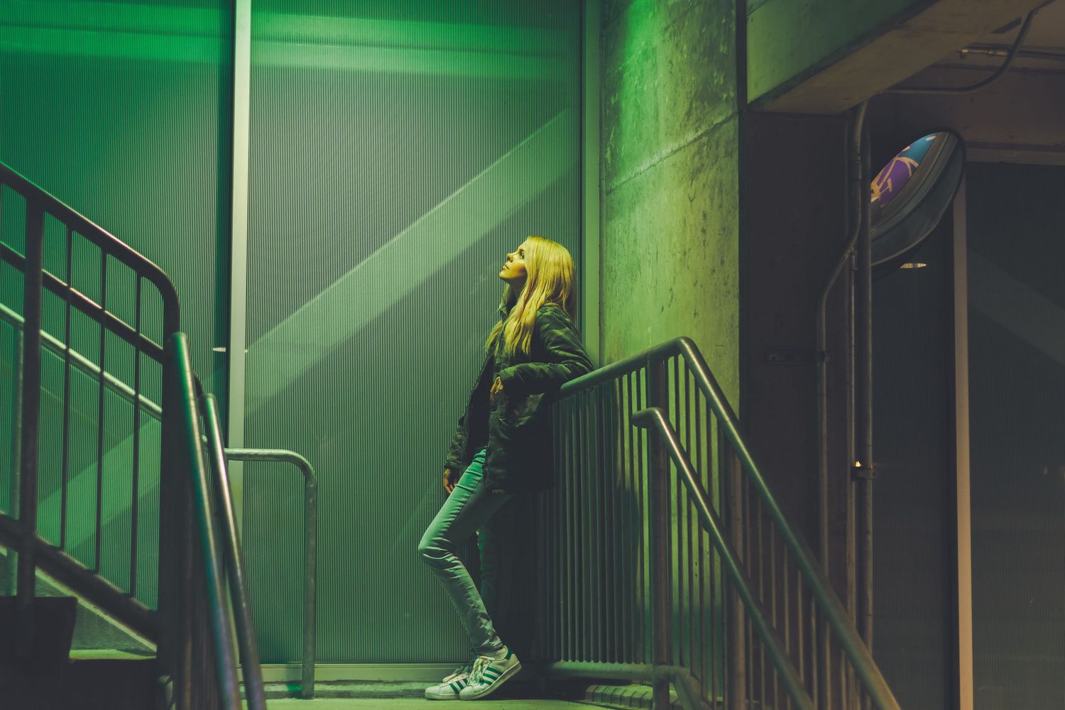 Dramatic green-lit urban stairwell captured in sequence.