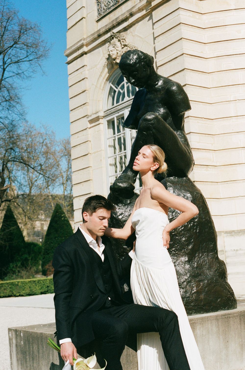 A sequence of artistic black and white fashion photos showing a scene between two people against a classic building exterior.