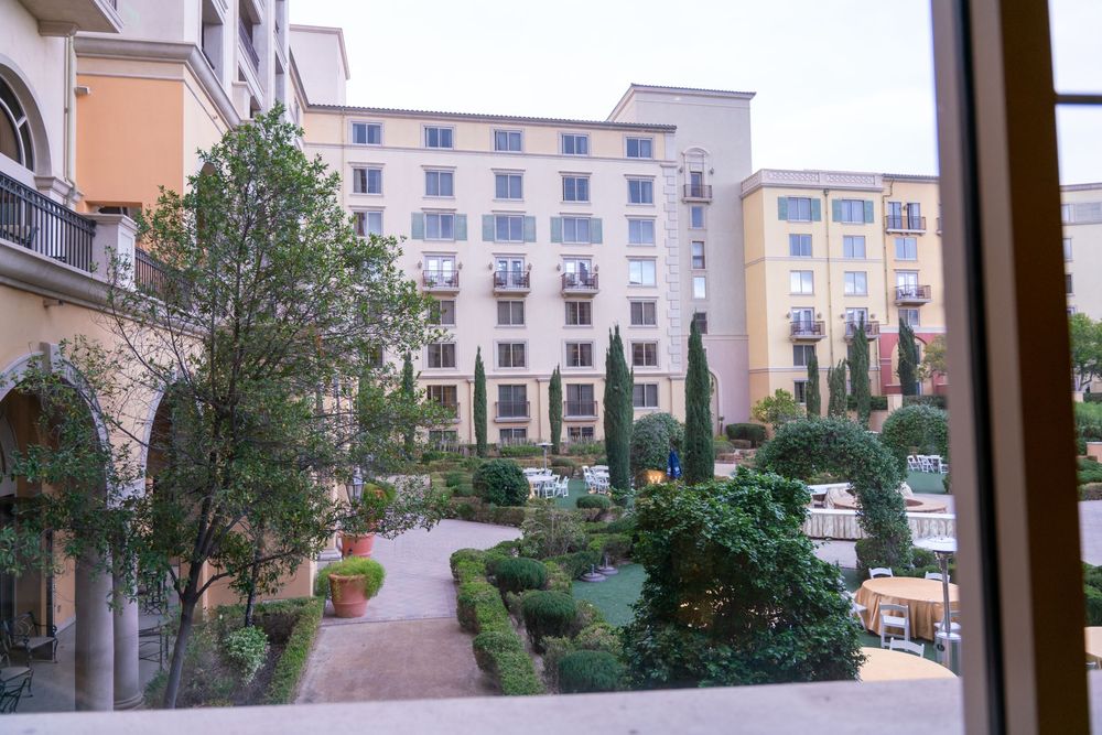 A panoramic view of a Mediterranean-style apartment complex with beige buildings and landscaped courtyards.