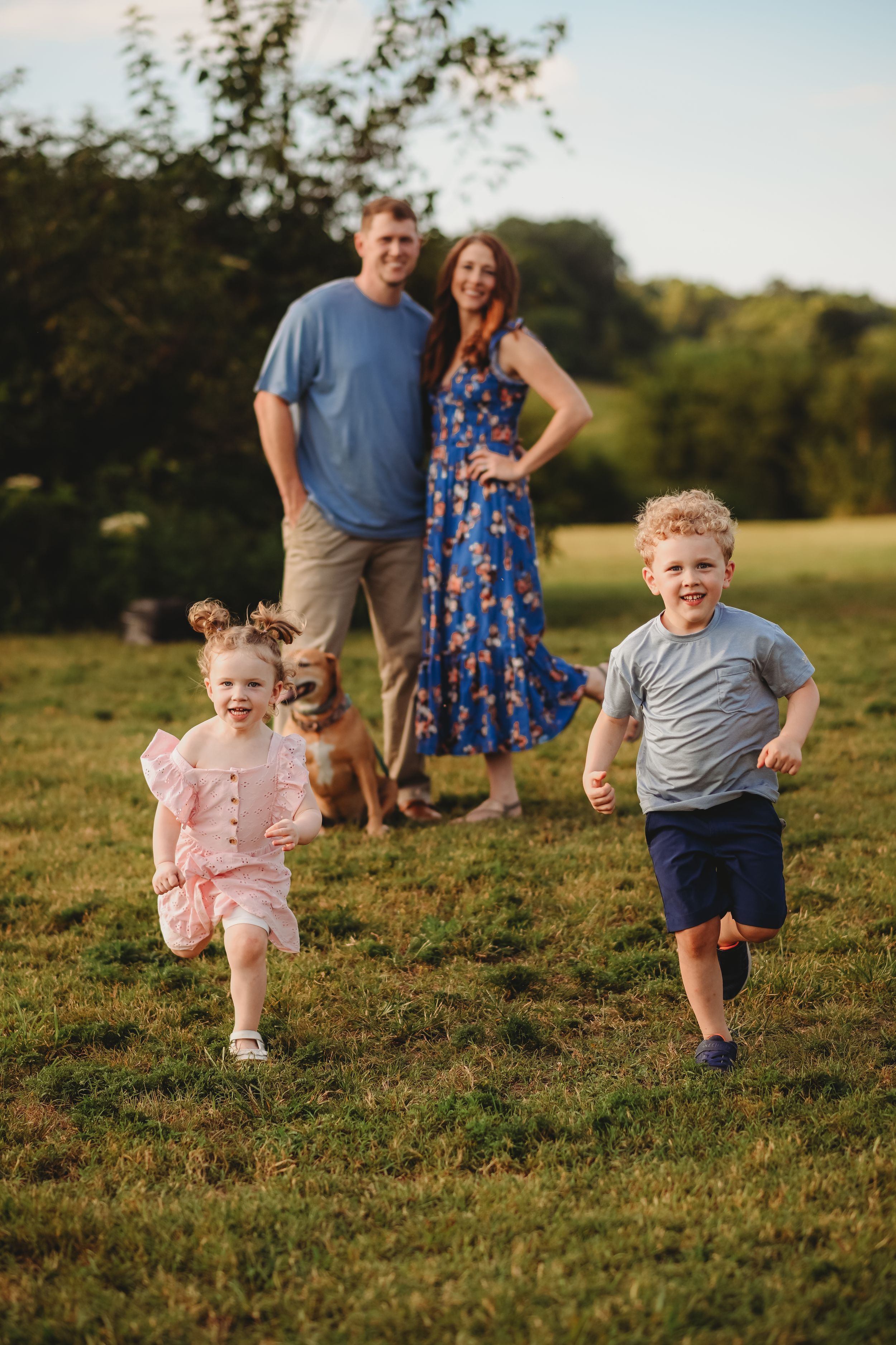 Children run and play in a grassy field during golden hour.
