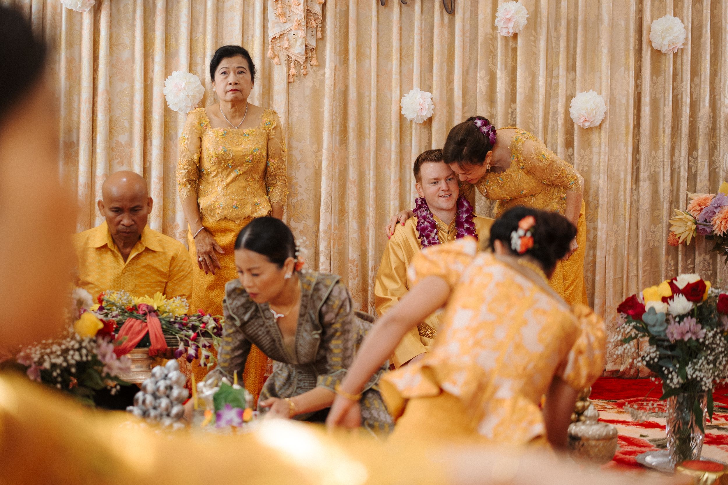 Group of guests seated at a decorated event table with golden accents and floral arrangements.