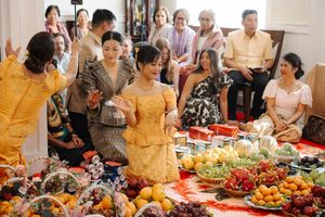 People enjoying a festive buffet spread with various dishes, fruits, and refreshments at a social gathering.