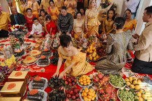 Festive table filled with colorful Mediterranean dishes and appetizers being enjoyed by a group of people at dinner party.