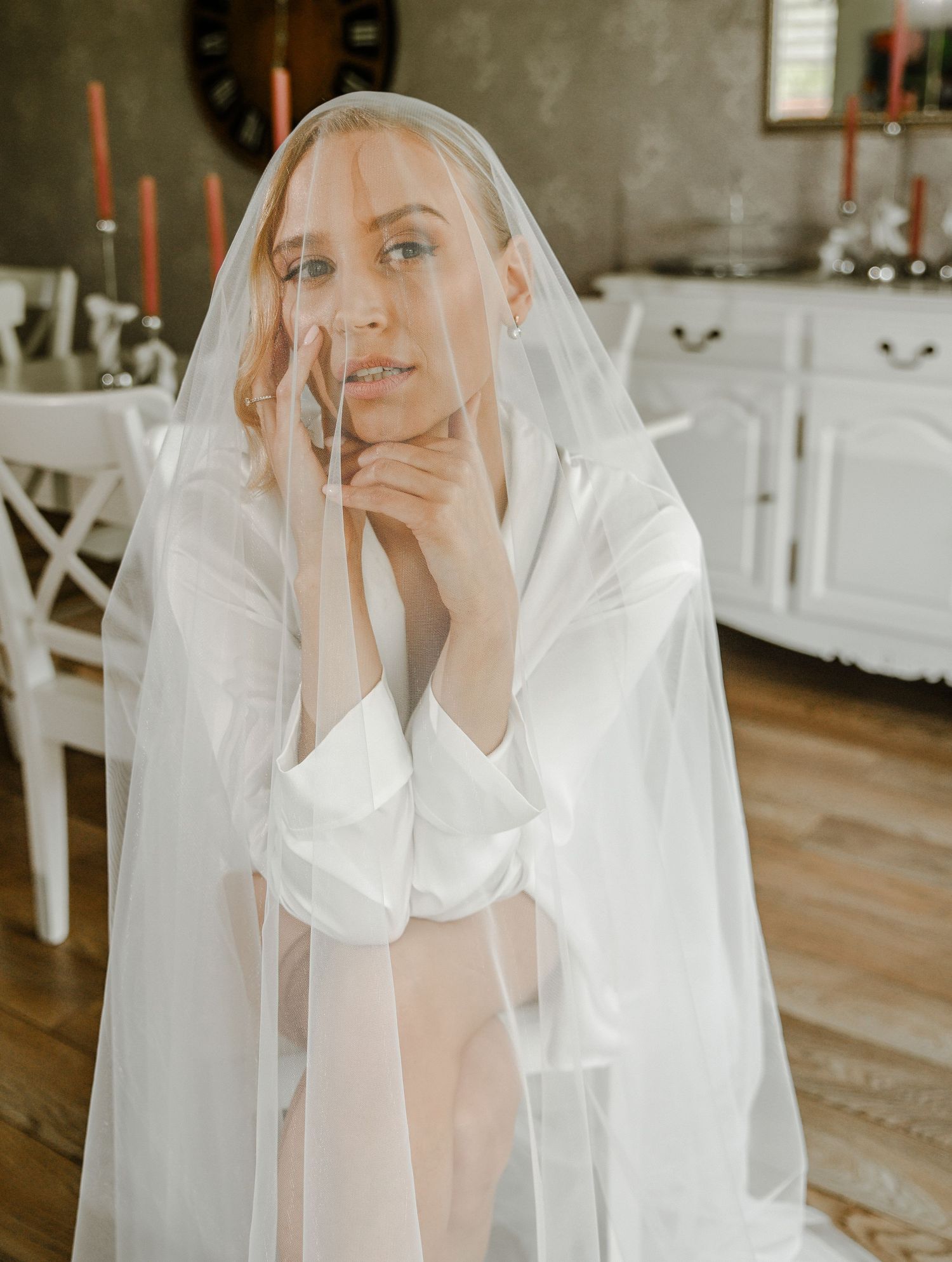 Delicate bridal portraits showing ethereal moments with a flowing white veil in an indoor setting.
