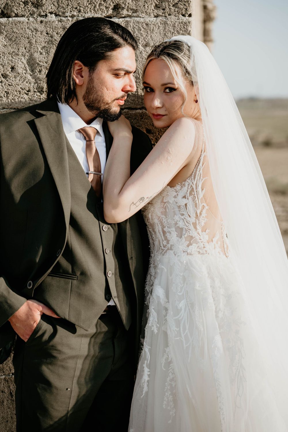 Romantic wedding couple in intimate poses against stone wall showing tender moments in a multi-frame series.