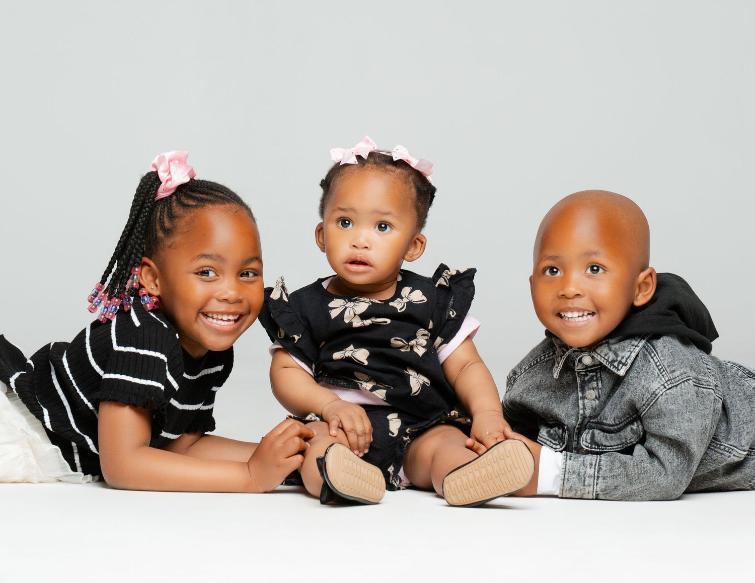 A series of black and white professional portraits showing adorable children posing and playing together.