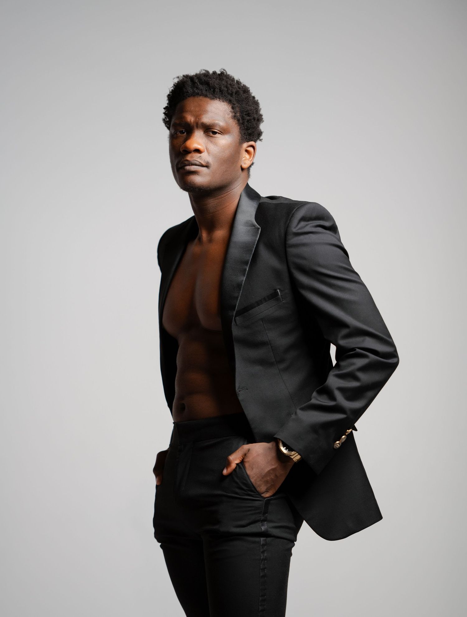 A dramatic fashion portrait series showing a model in a black blazer against a light background, creating striking contrast.