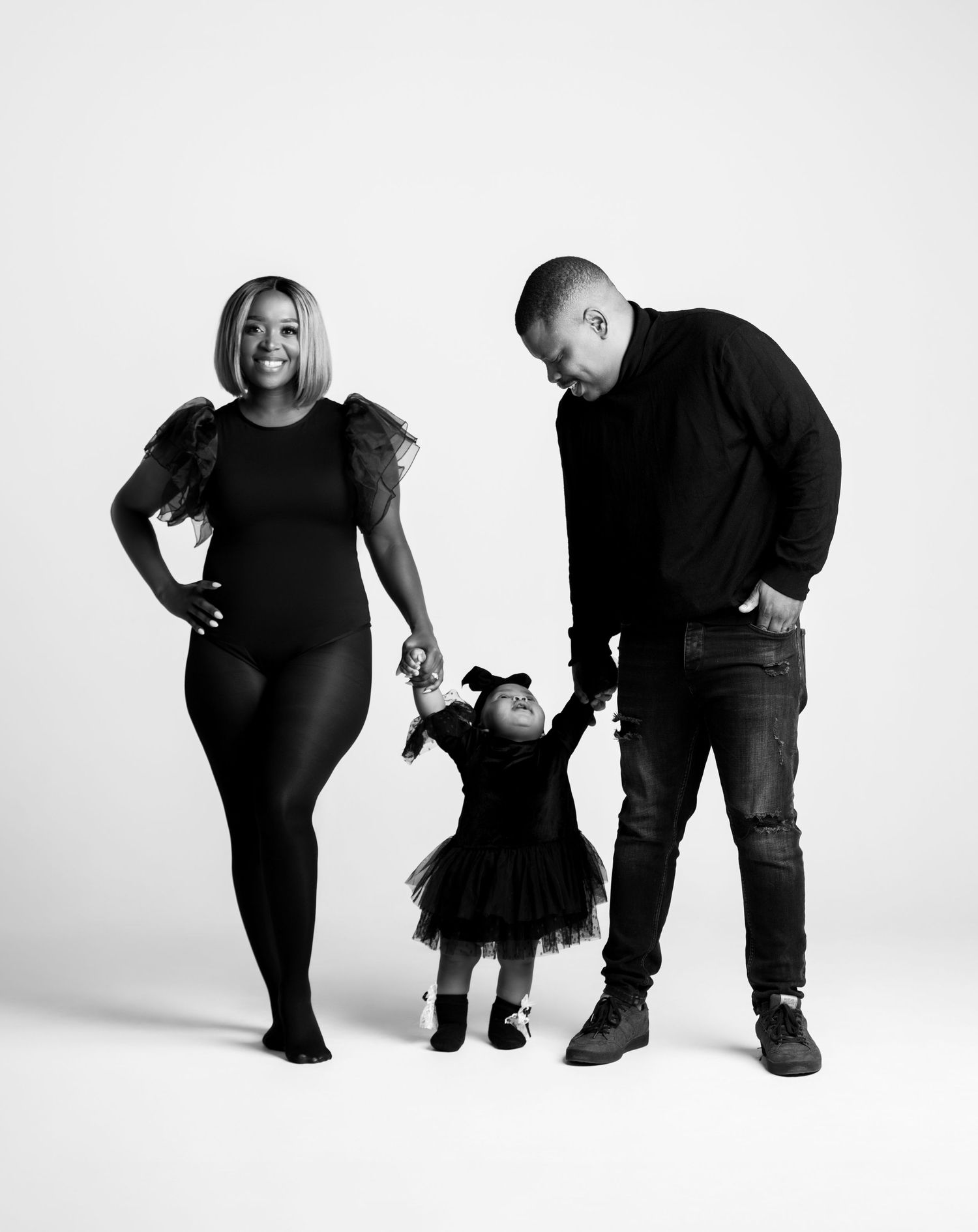 Black and white family portrait series showing three figures in matching dark outfits against white background.