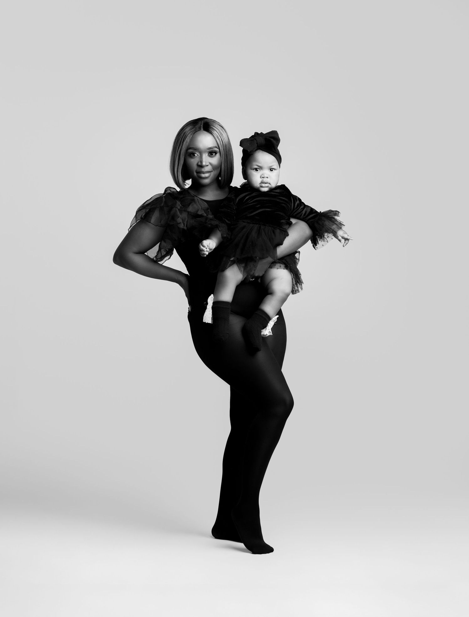 Artistic black and white dance poses of figures in dark clothing against minimalist white backdrop.