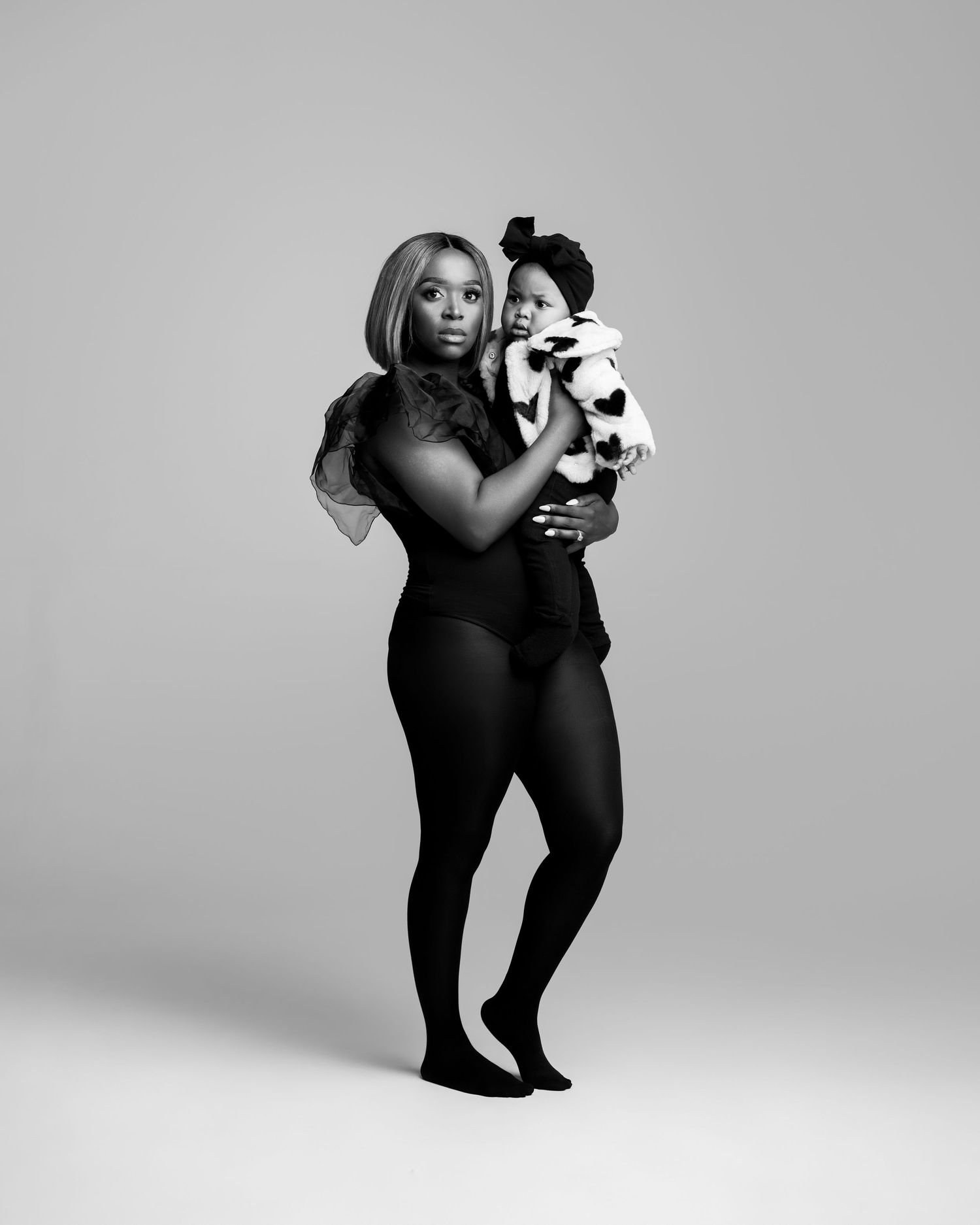 Black and white fashion photo series showing a model in black clothing striking dynamic poses against a light background.