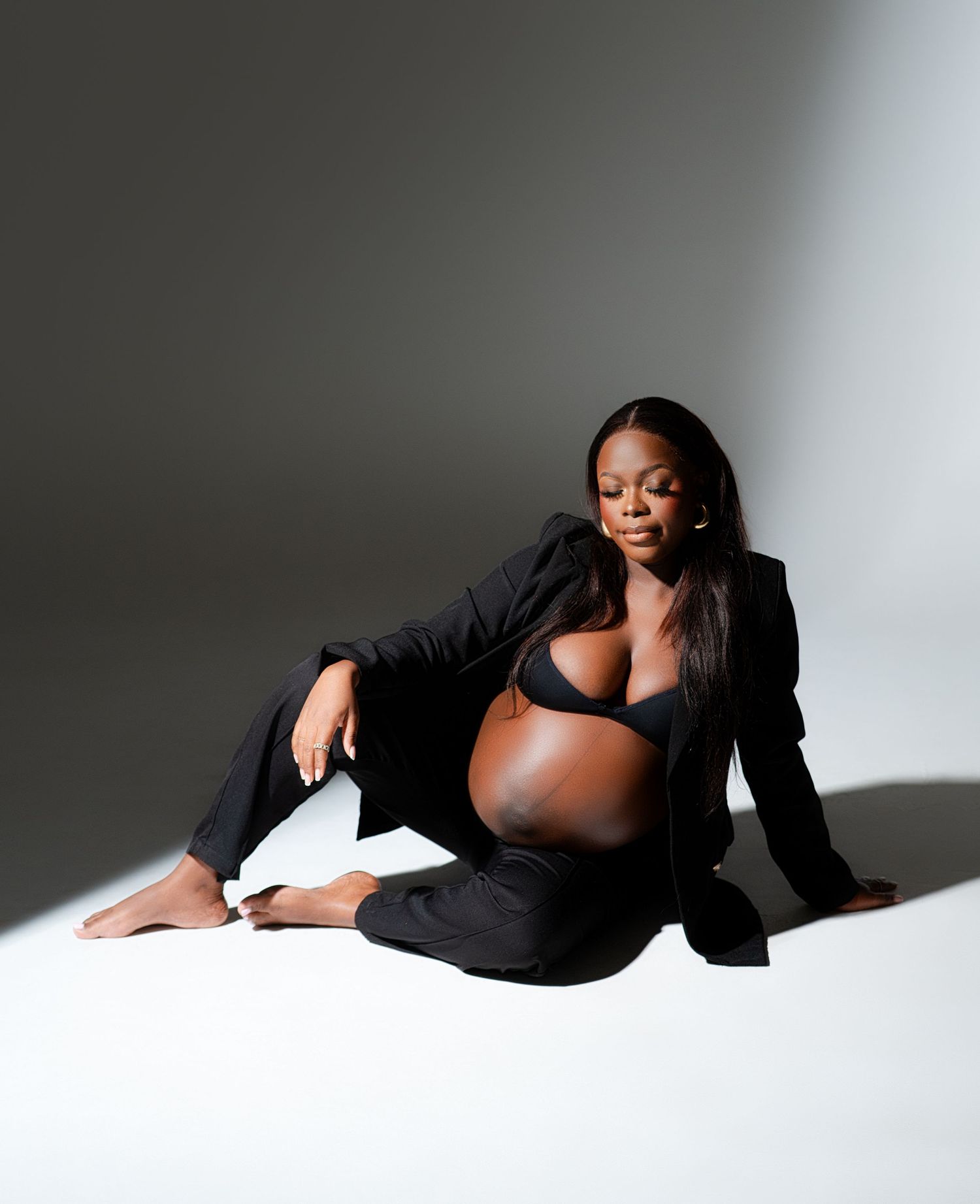 A figure in a black dress poses elegantly against a white backdrop in a series of artistic reclining positions.