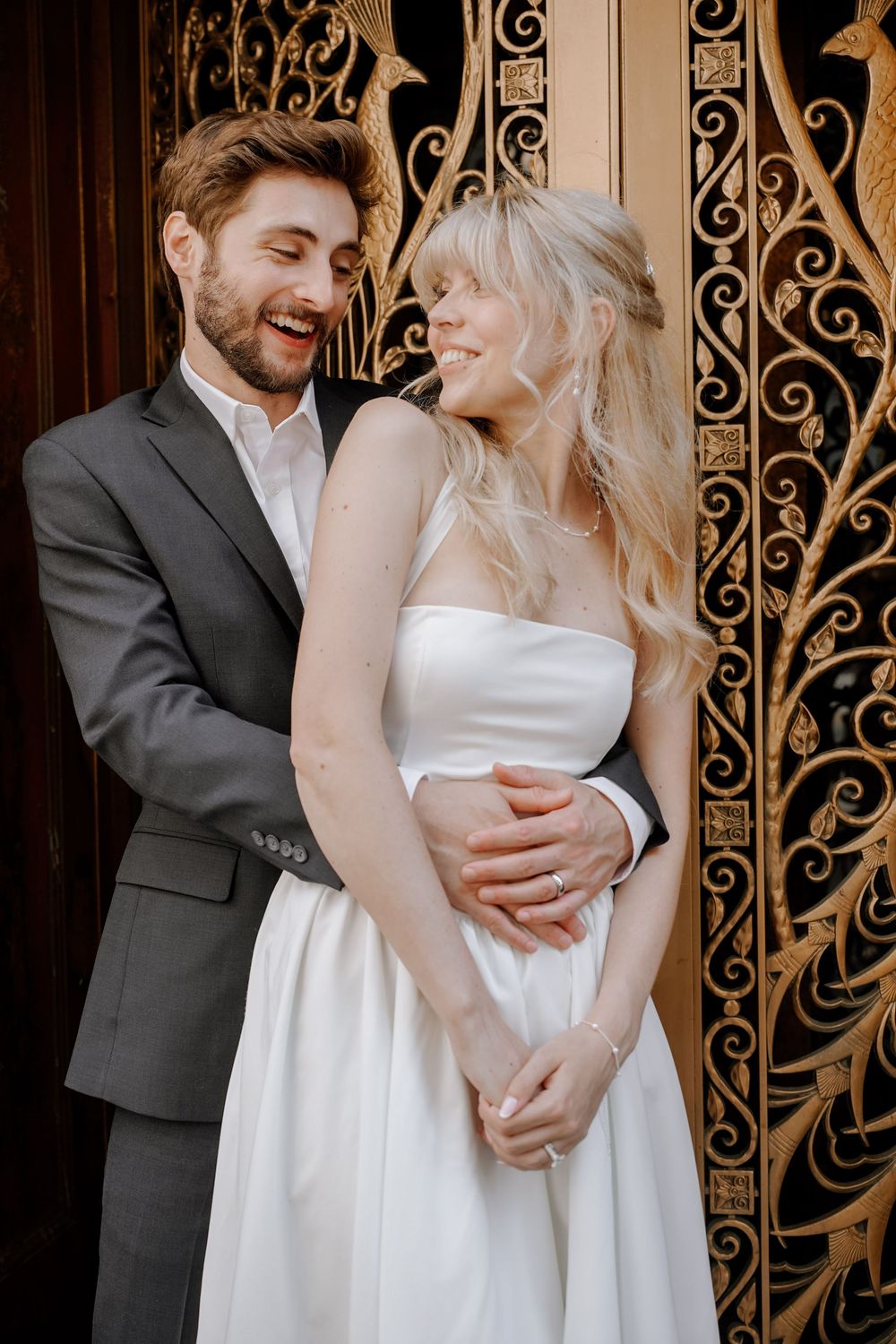 Romantic wedding photo series showing couple embracing against ornate wrought iron gate background.