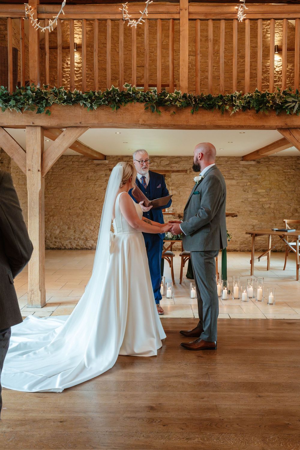 Kingscote Barn Wedding Photographer Zara Davis Photography Cotswolds Gloucestershire Cheltenham bride groom in barn during ceremony