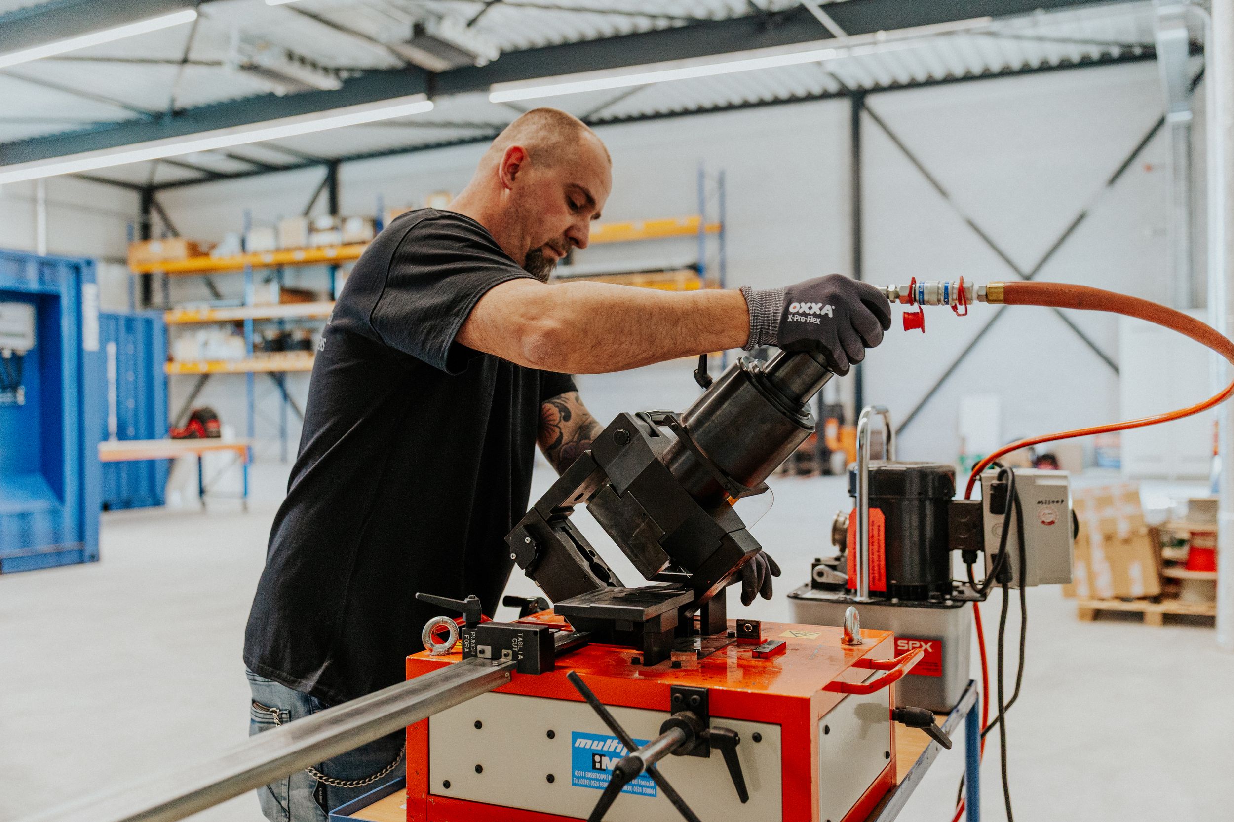 Technicians working on industrial machinery in large warehouse facility.