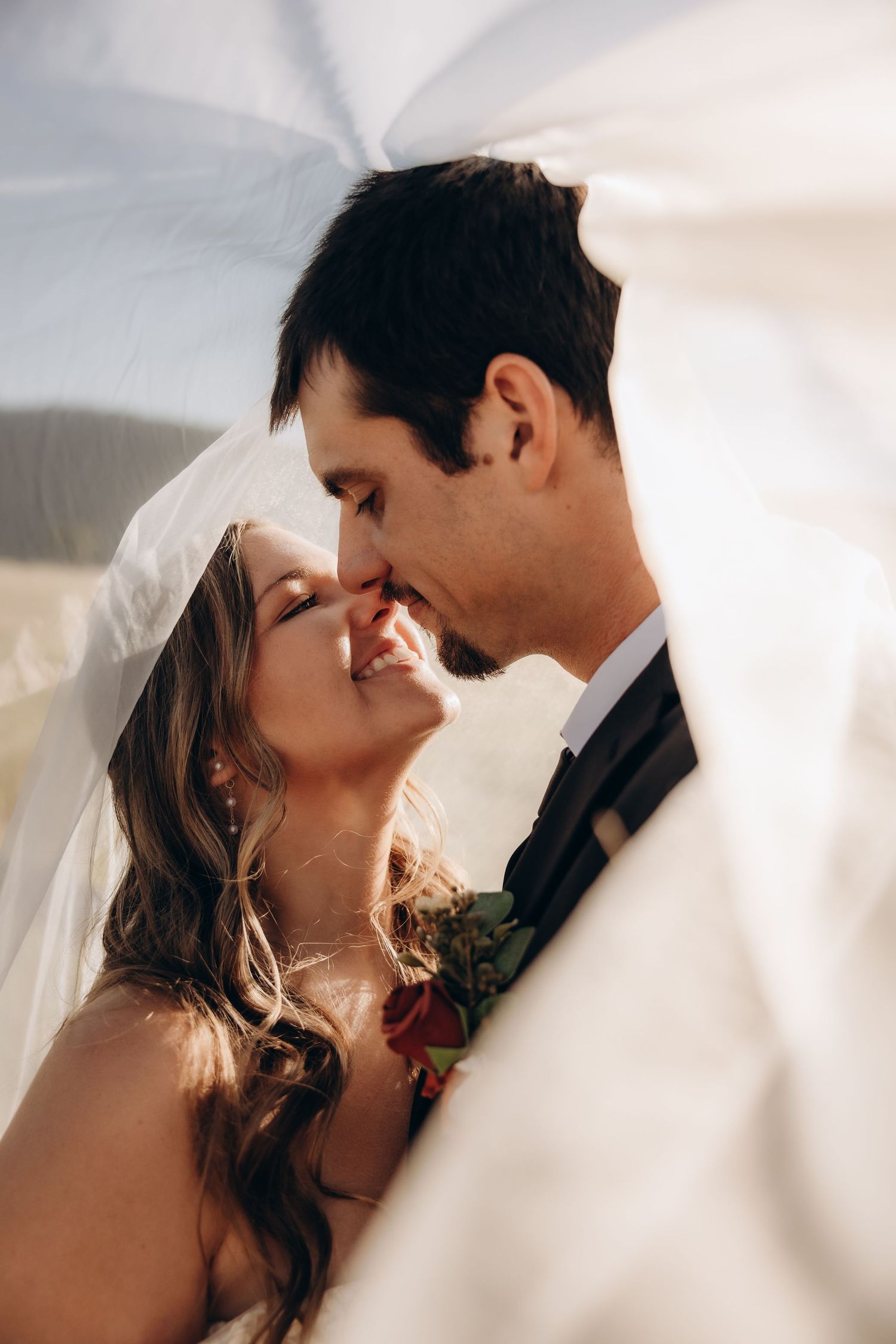 A romantic wedding moment captured through a veil showing multiple angles of a couple's kiss.
