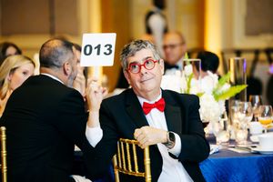 Guests in formal attire enjoying themselves at an elegant indoor reception or gala event.