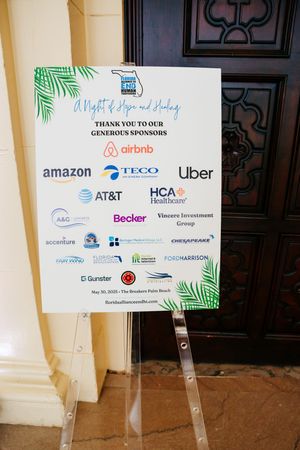 A sponsor appreciation sign with logos including Airbnb, Amazon, Uber and other companies displayed on an easel stand.