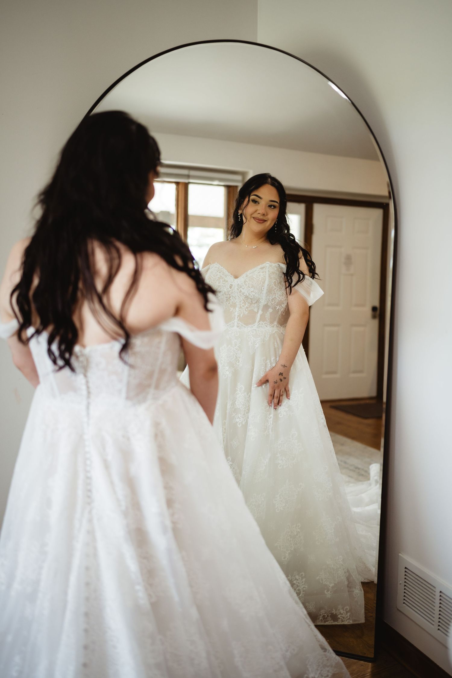 A series of delicate white wedding dresses shown side by side, displaying intricate lace and tulle details.