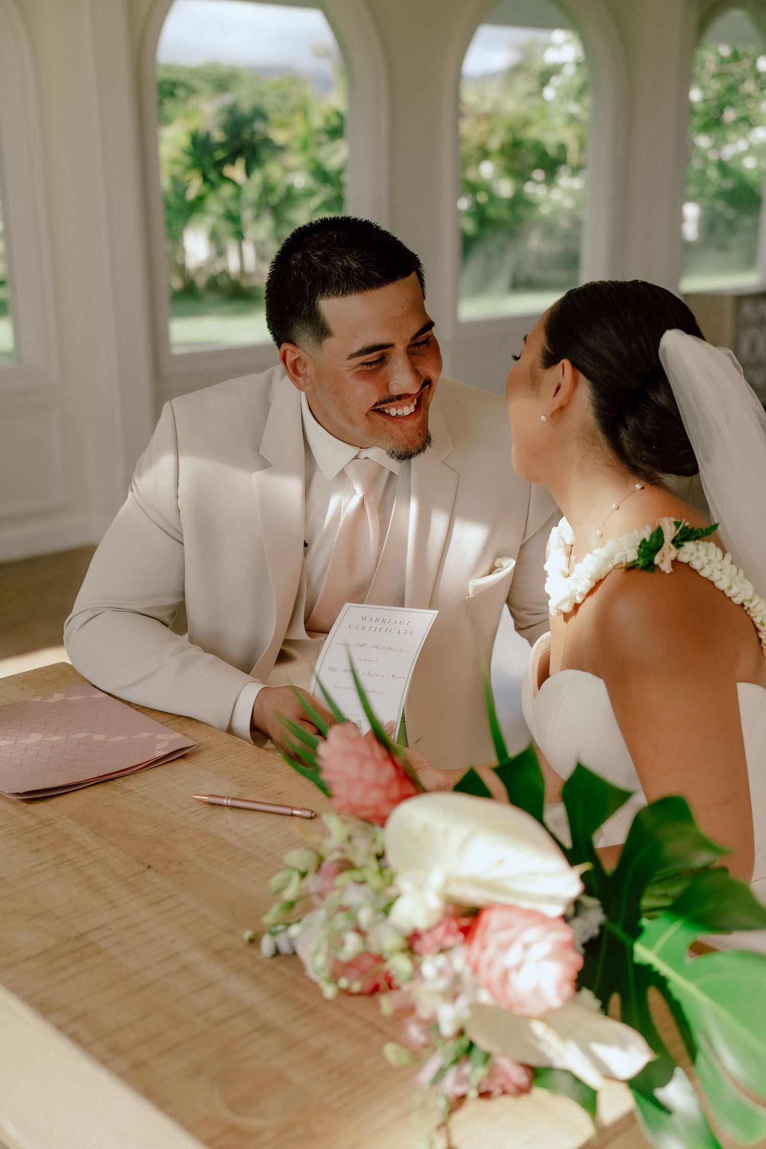 A happy couple shares intimate laughs during their wedding photo session at an elegant indoor venue.
