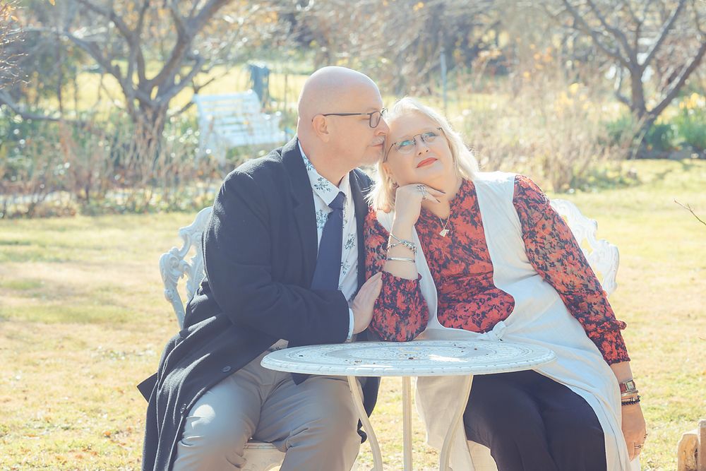 A romantic outdoor photoshoot series shows a couple embracing and kissing in a natural sunlit setting.