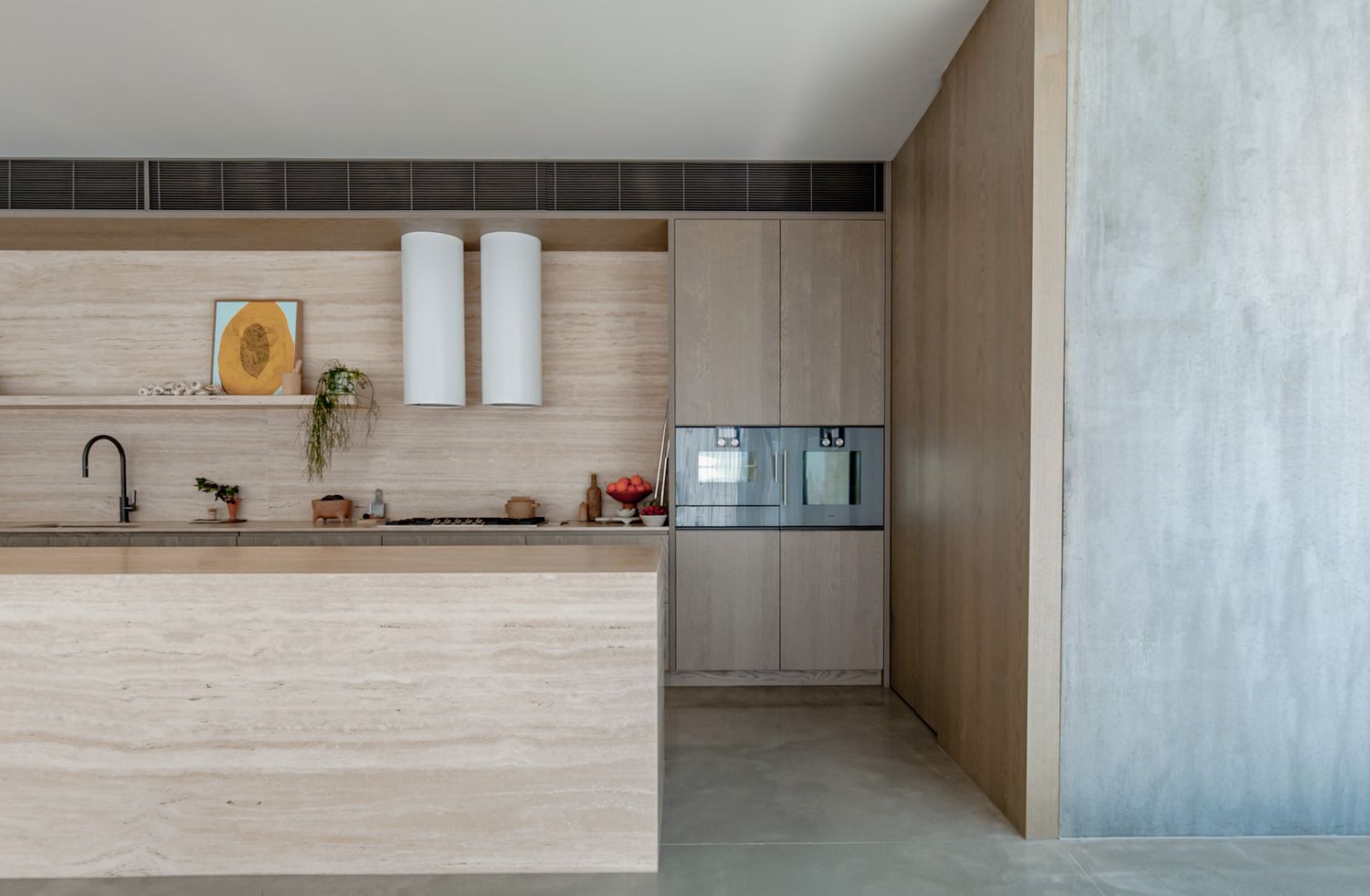 Contemporary open-concept kitchen with light wood paneling and industrial concrete finishes in a wide angle view.