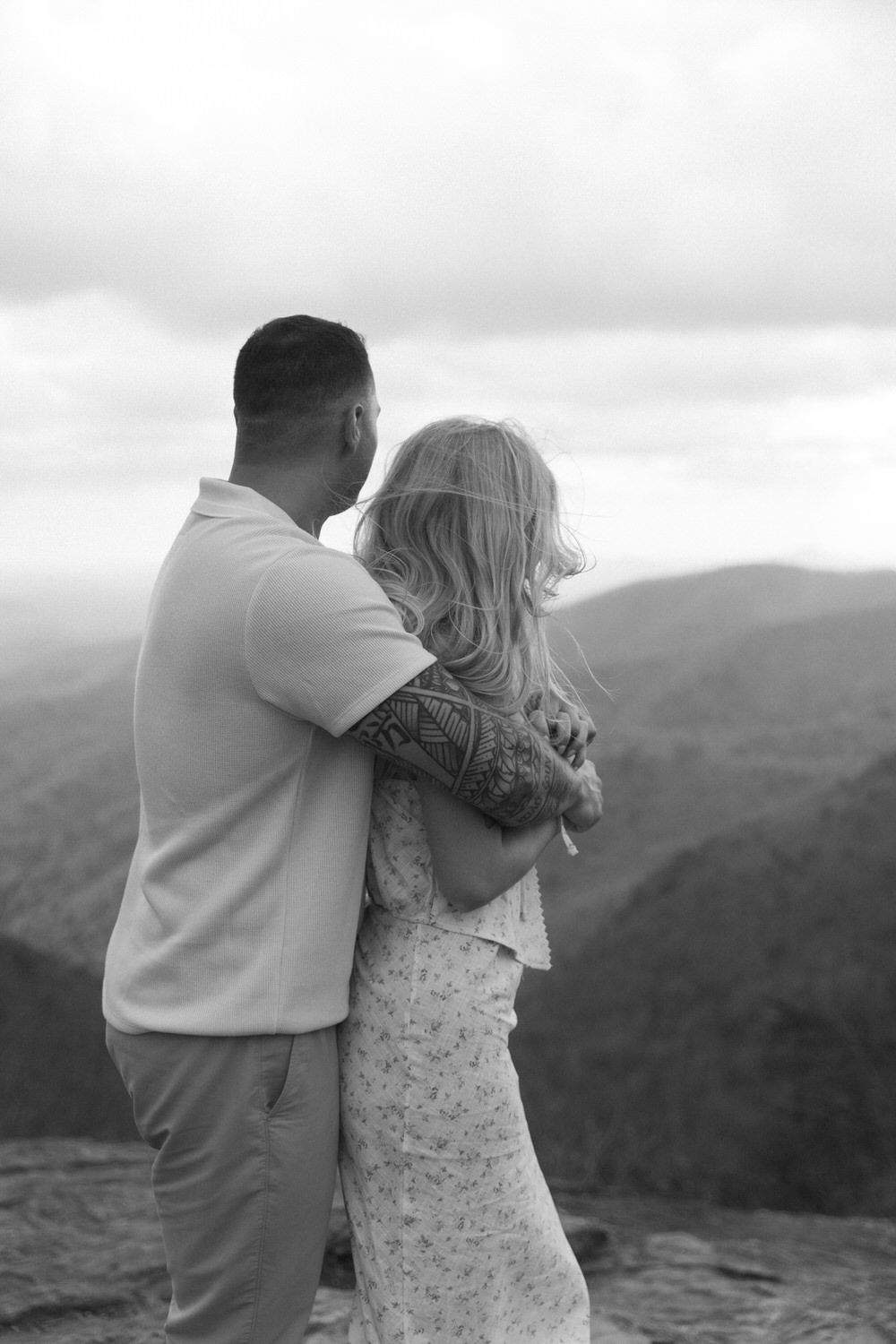 Couple standing on Preacher’s Rock with Blue Ridge Mountains behind them