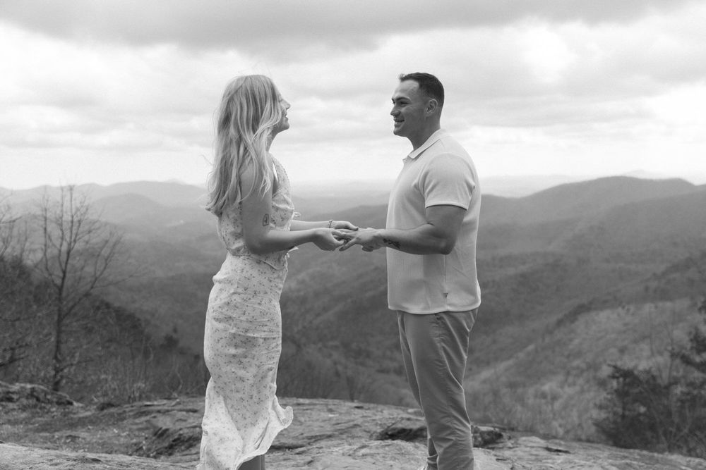 Bride and groom exchanging rings on Preacher’s Rock overlook in North Georgia mountains