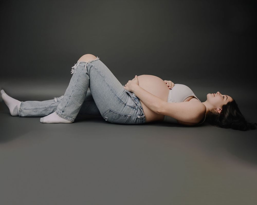 A series of artistic boudoir photographs showing a figure in gray loungewear reclining in different poses against a dark background.
