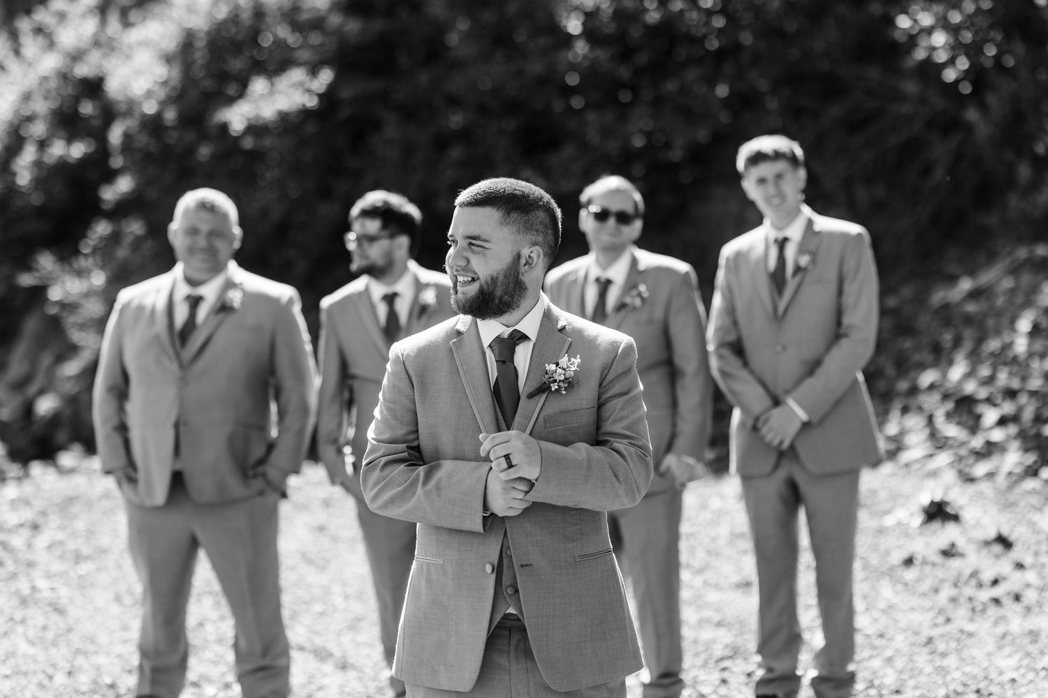 A group in formal grey suits and ties walking in a line outdoors creating a dynamic portrait composition.