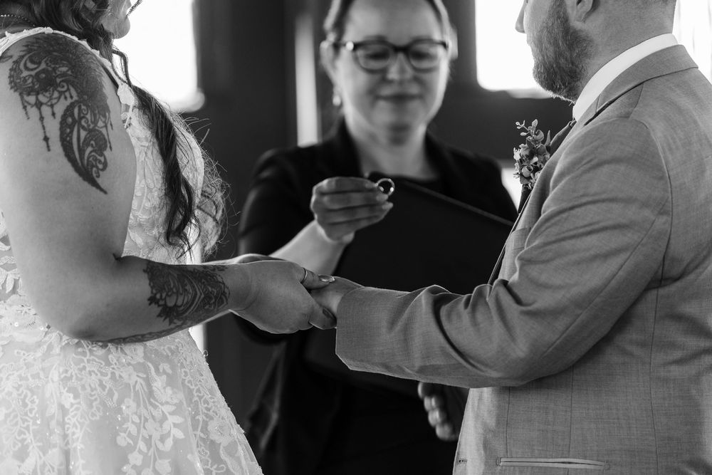 Black and white panoramic collage of candid wedding moments showing guests interacting at a celebration.