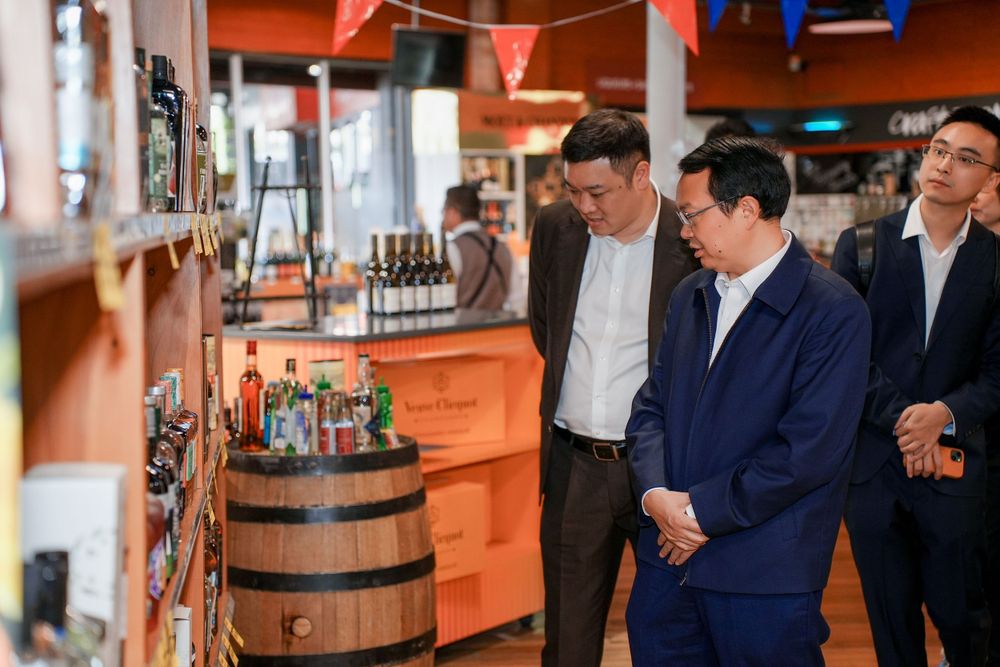 Corporate event photography of a business delegation inspecting a liquor store, by an Auckland commercial photographer.